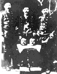 tre militari turchi posano mostrando due teste di decapitati armeni 